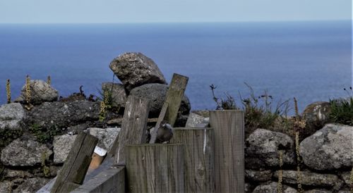 Rocks by sea against sky