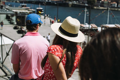 Rear view of people sitting in city during sunny day