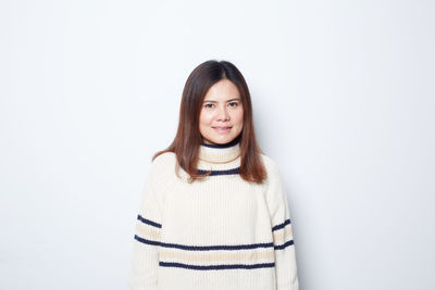 Portrait of a smiling young woman against white background