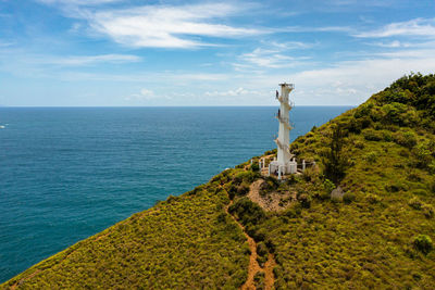 Aerial drone of lighthouse on a hill against the blue sky. santa ana,luzon, philippines.