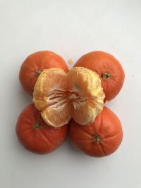 High angle view of orange fruit against white background