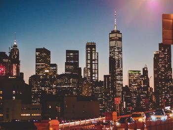 Illuminated buildings in city against sky at night