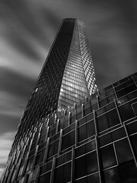 Low angle view of modern building against cloudy sky