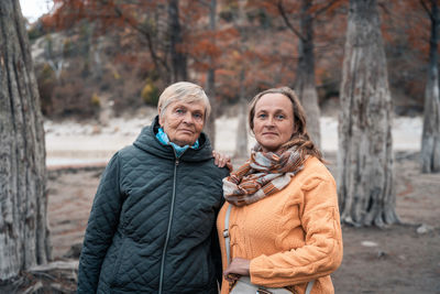 Portrait of female friends in forest during winter