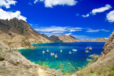 Scenic view of sea and mountains against blue sky