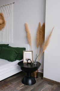 Bedroom decor in boho style. bedside table and dried flowers in a vase