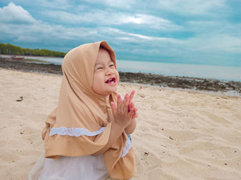 Midsection of woman at beach against sky