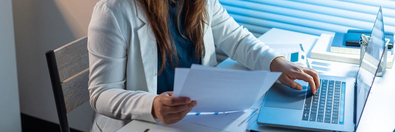 Midsection of businesswoman working at office