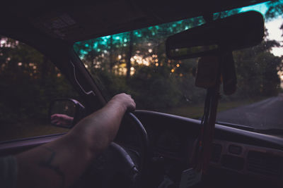 Cropped hand of man driving car