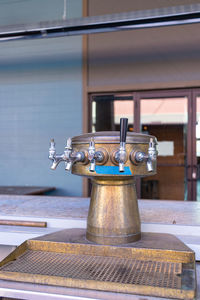 Close-up of faucet on table against building