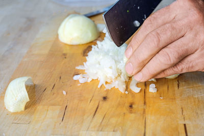 Cropped hand of person preparing food on table