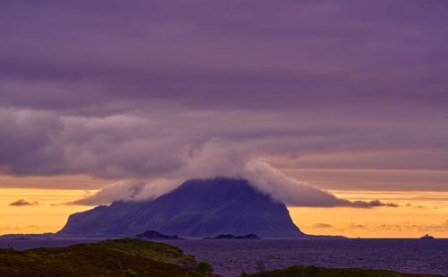 Scenic view of clouds over a mountain island against sky at sunset 