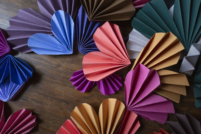 Multi-colored paper hearts on wood surface for valentine's day