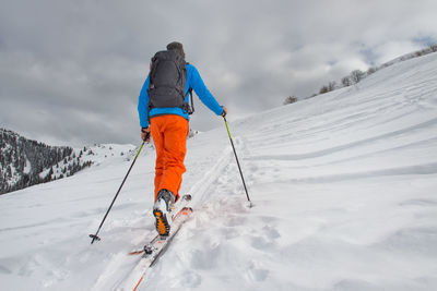Low angle view of man skiing on snow covered field