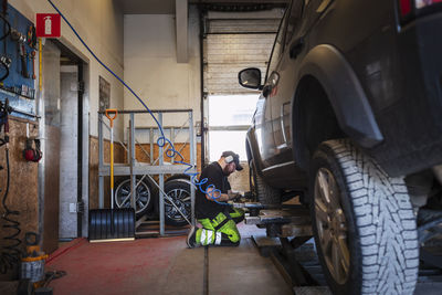 Mechanic in garage repairing car