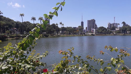 Scenic view of river by buildings against sky