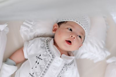 Portrait of cute baby lying on bed