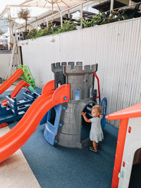 High angle view of boy standing by toy car