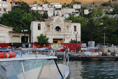 Boats moored in canal by buildings in city