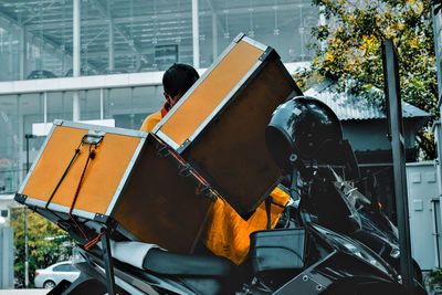 Man with container on motor scooter 