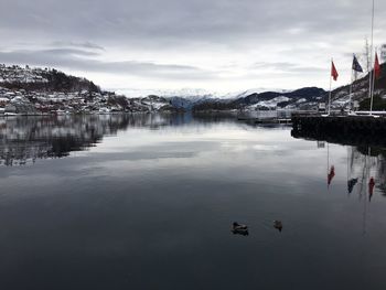 Boats in sea against cloudy sky