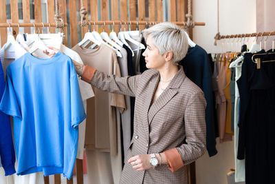 Woman choosing dress at store