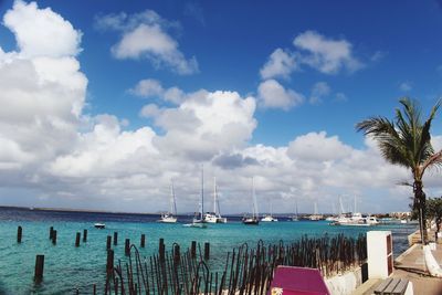 Boats in sea against cloudy sky