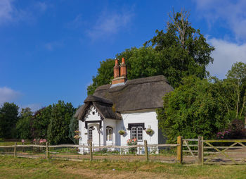 House amidst trees and building against sky