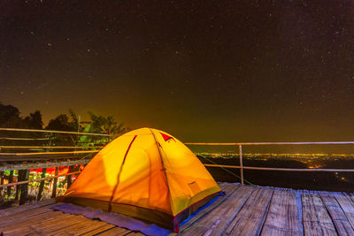 Illuminated tent against sky at night