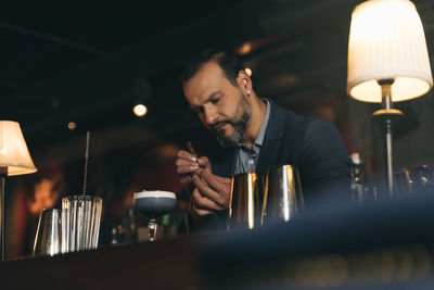 Male bartender preparing cocktail at bar counter