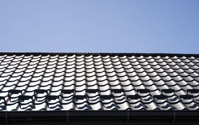 Low angle view of roof tiles against sky