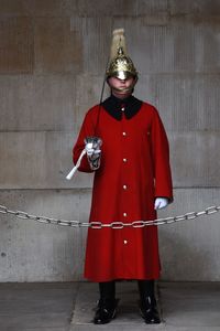 Portrait of honor guard standing against wall