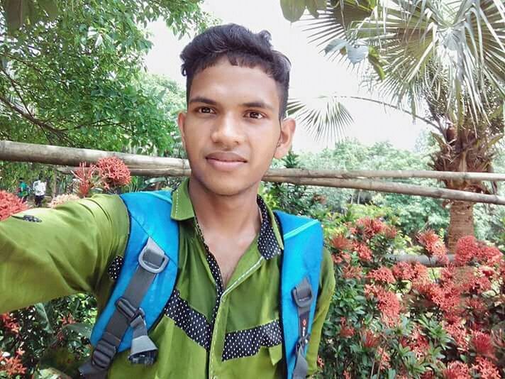 PORTRAIT OF SMILING YOUNG MAN AGAINST TREES