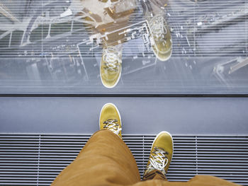 Top view on man's feet in yellow leather sneakers. urban fashion of millennials.