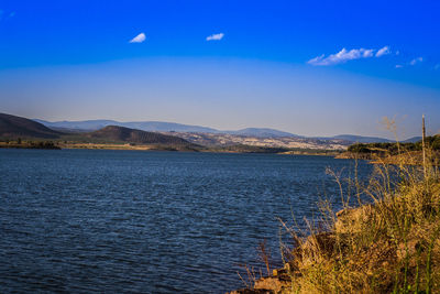 Scenic view of river by mountain against sky