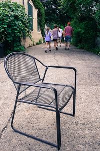 Rear view of two people walking in front of building