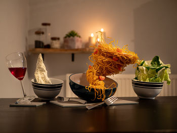 Food and drink levitating over dining table at home