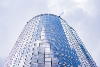 Low angle view of modern glass building against sky