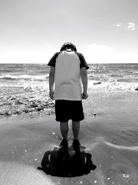 Rear view of woman standing on beach
