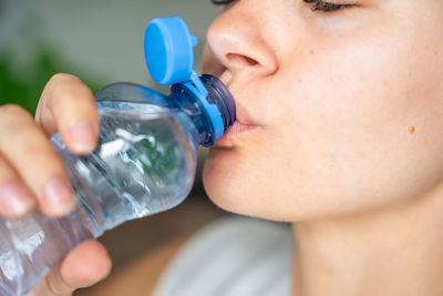 Close-up of woman drinking water