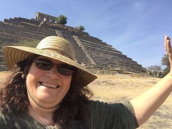 Portrait of smiling woman in hat against sky