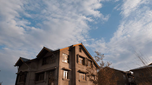 Low angle view of buildings against cloudy sky