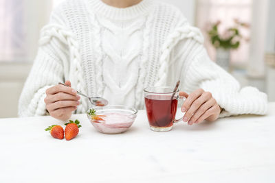 Midsection of woman using mobile phone on table