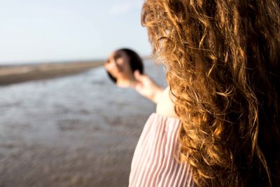 Portrait of woman at beach against sky