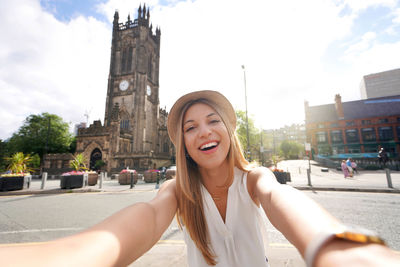 Smiling girl takes selfie photo in manchester, england, united kingdom