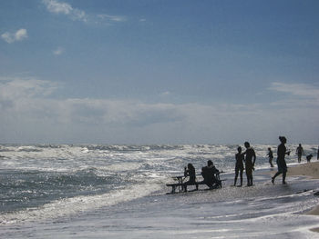 People on beach against sky