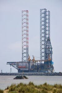 Crane at construction site against sky