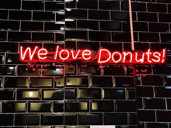 Low angle view of illuminated neon sign at night