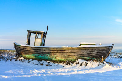 Abandoned ship in snow against clear sky