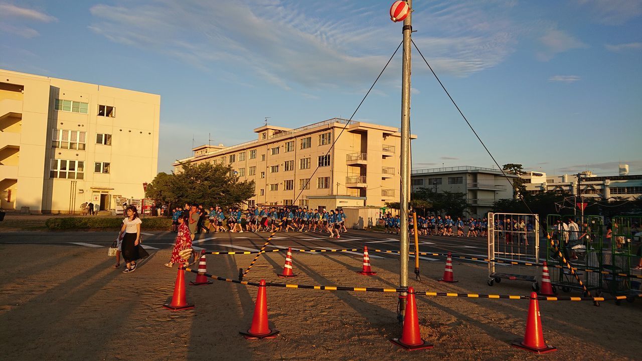 PEOPLE WALKING ON ROAD AGAINST BUILDINGS